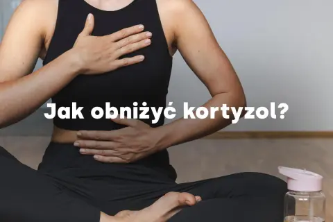 Kobieta w pozycji medytacyjnej, z dłońmi na brzuchu i klatce piersiowej, pokazuje jak obniżyć kortyzol.